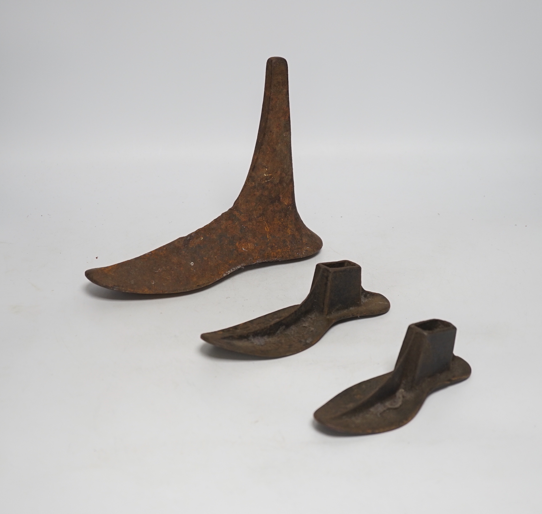 Six cast iron cobbler's forms and a door stop